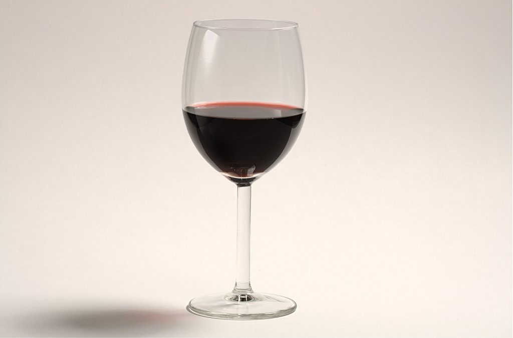 Verre de vin rouge servi en extérieur pour accompagner un barbecue d'été