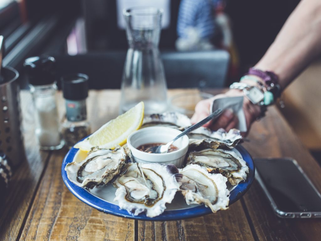 Assiette d'huîtres fraîches accompagnée d'un verre de vin blanc