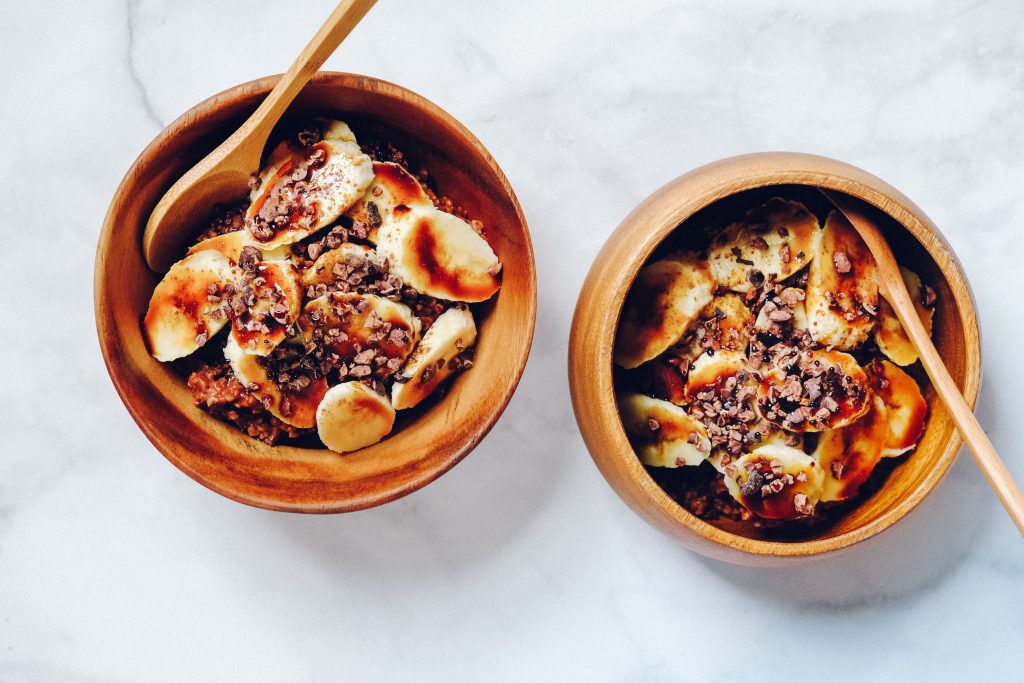 Bol de porridge aux flocons d'avoine garni de rondelles de banane et de fruits rouges