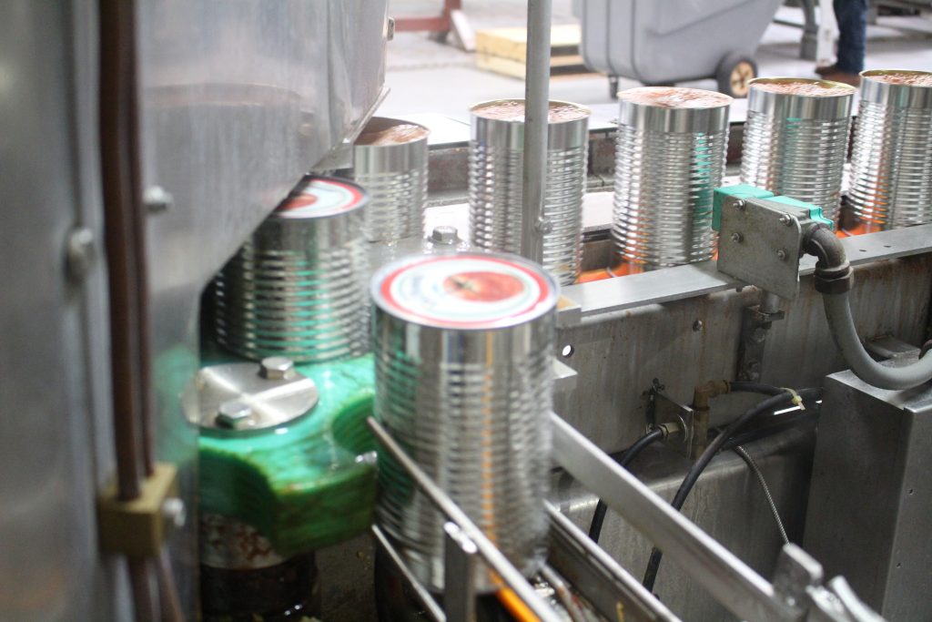 Sertissage industriel du couvercle sur une boîte de conserve de tomates