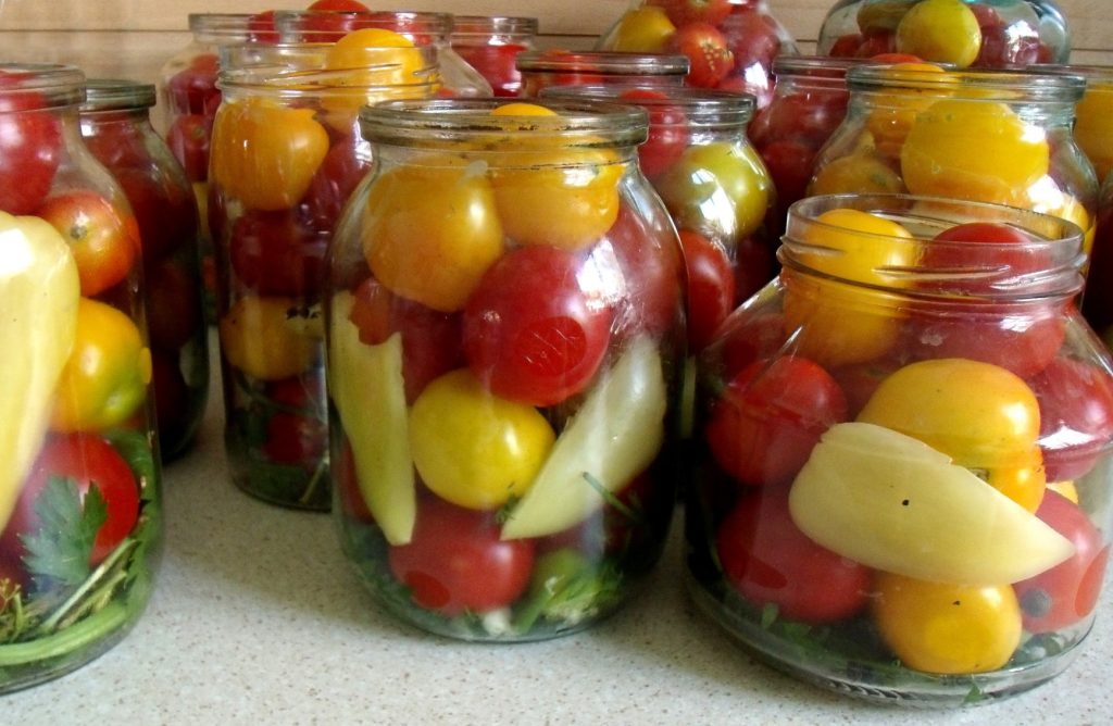 Tomates fraîches en cours de mise en conserve dans des bocaux de verre