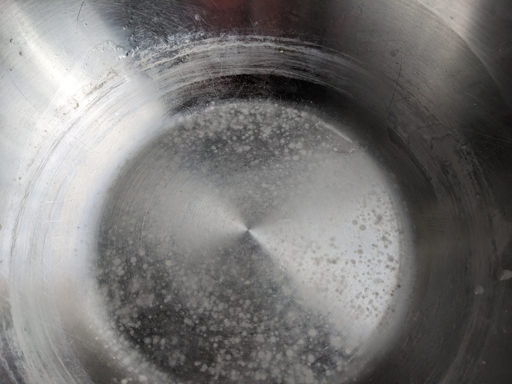 Dépôt de calcaire blanchâtre au fond d'un récipient après chauffage de l'eau