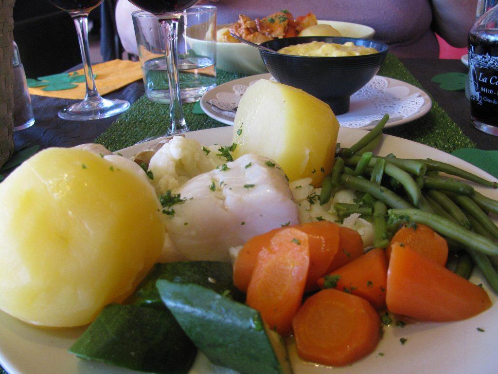 Assiette de grand aïoli garni avec morue, légumes vapeur et œufs durs servie en Provence