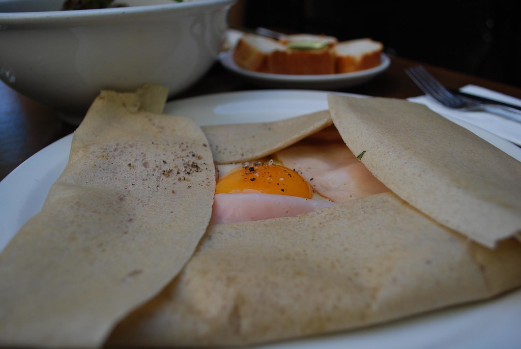 Galette complète de blé noir avec œuf, jambon et fromage servie en crêperie