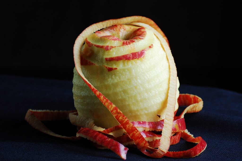 Épluchage des pommes au couteau avant la cuisson de la compote