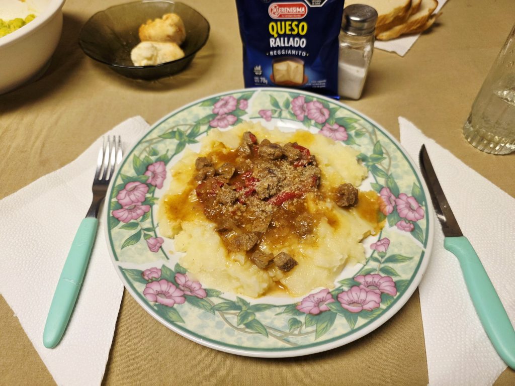 Hachis parmentier gratiné servi dans une assiette, purée dorée sur viande hachée en sauce