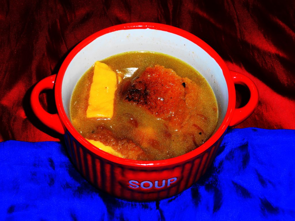 Soupe à l'oignon gratinée servie en cassolette avec croûton et fromage fondu