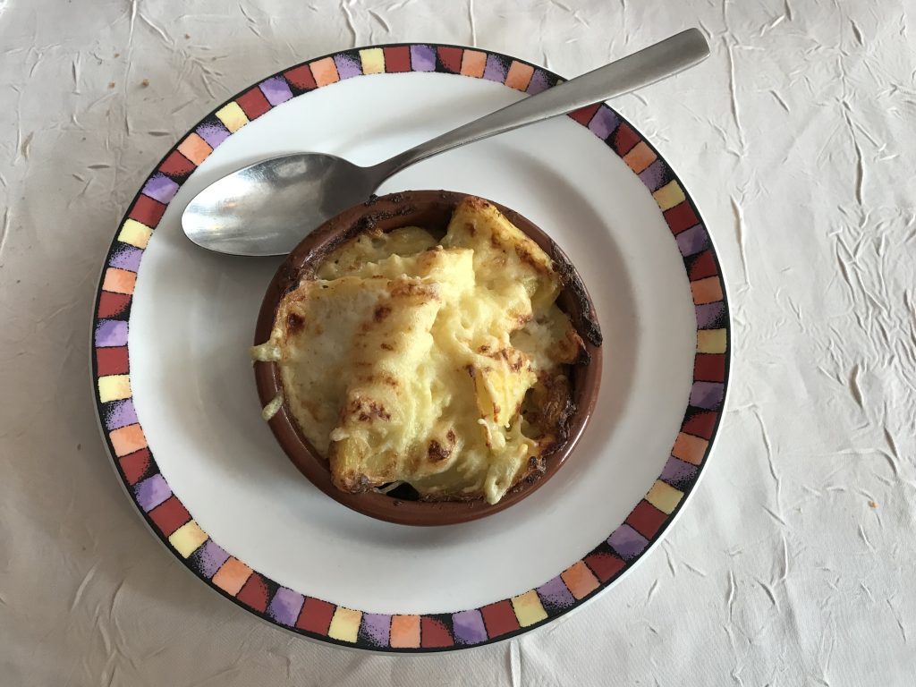 Gratin dauphinois doré et crémeux servi à la cuillère