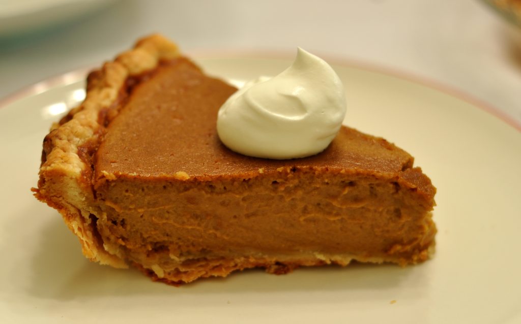Part de tarte à la citrouille parfumée au pumpkin spice avec crème fouettée