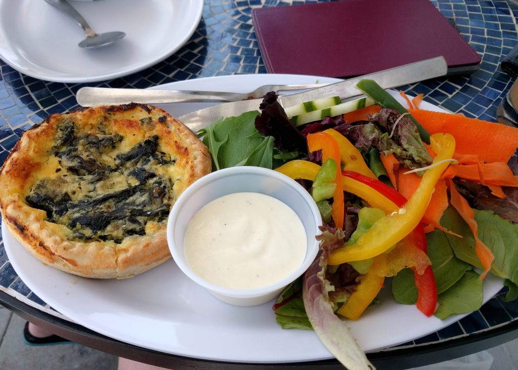 Part de quiche servie avec une salade verte
