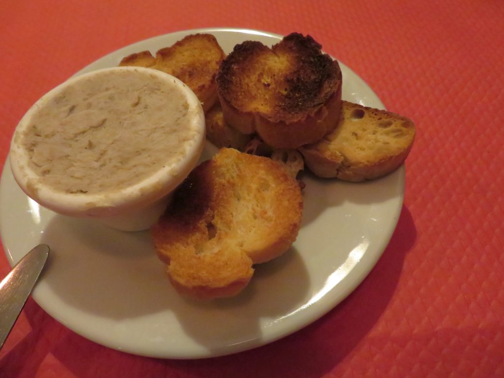 Rillettes de porc servies avec des tranches de pain de campagne grillé