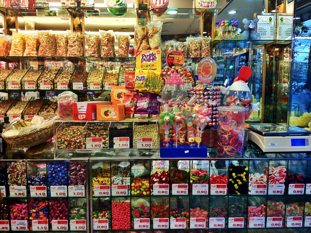 Rayon de confiserie avec bonbons colorés présentés en vrac dans une boutique
